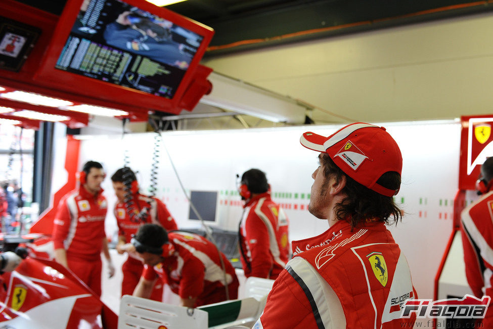 Alonso mira la sesión de clasificación desde su box