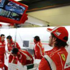 Alonso mira la sesión de clasificación desde su box