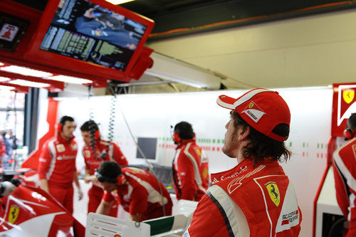 Alonso mira la sesión de clasificación desde su box