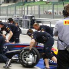 Un técnico de Pirelli vigila el RB7 de Webber