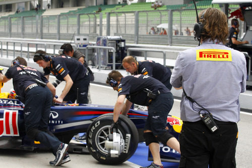 Un técnico de Pirelli vigila el RB7 de Webber