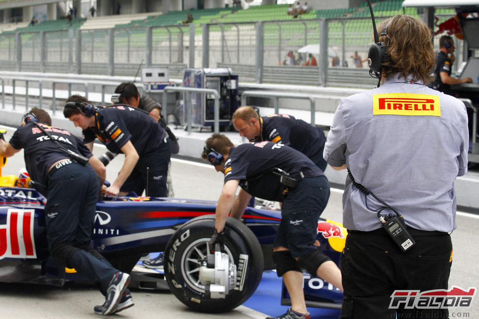 Un técnico de Pirelli vigila el RB7 de Webber