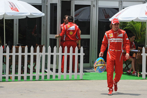 Fernando Alonso sale de su box con el casco en Malasia 2011