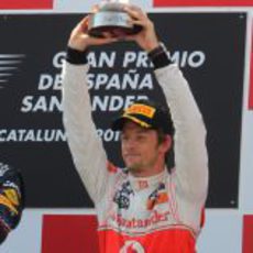 Button levanta su trofeo de tercer clasificado en el GP de España 2011