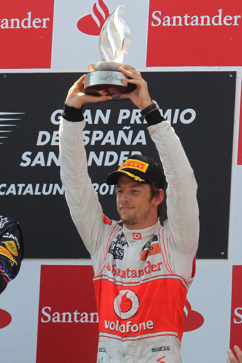 Button levanta su trofeo de tercer clasificado en el GP de España 2011