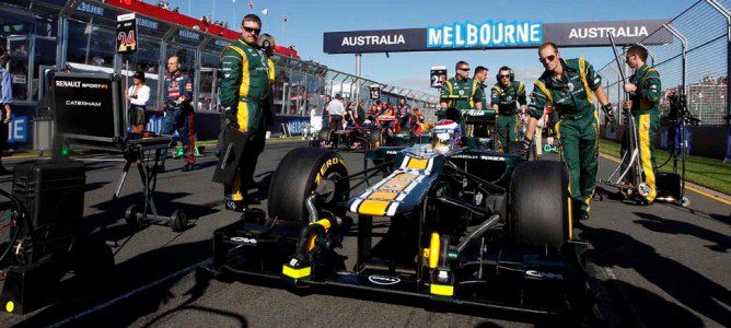 Los mecánicos meten a Vitaly Petrov en el box de Caterham en Australia