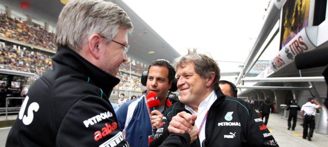 Norbert Haug y Ross Brawn celebran la pole de Nico Rosberg