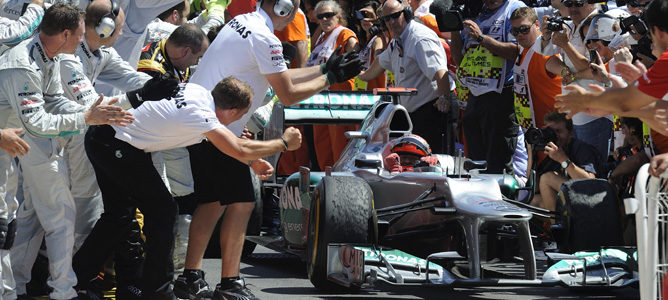 Michael Schumacher recibido por el equipo Mercedes tras lograr su podio en Valencia 2012