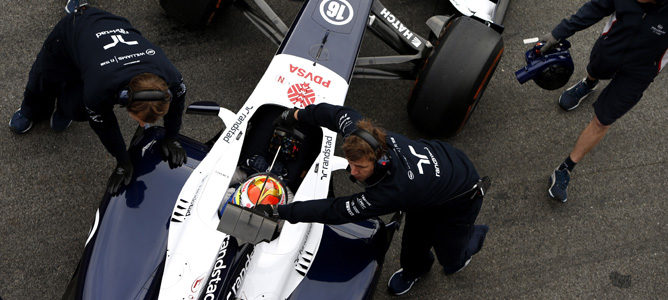 Los mecánicos de Williams empujan el FW35 al box