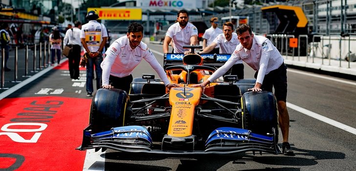 Los mecánicos de McLaren empujan el coche de Sainz