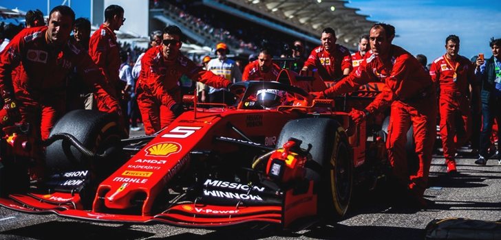 Los mecánicos de Ferrari empujan el coche de Vettel